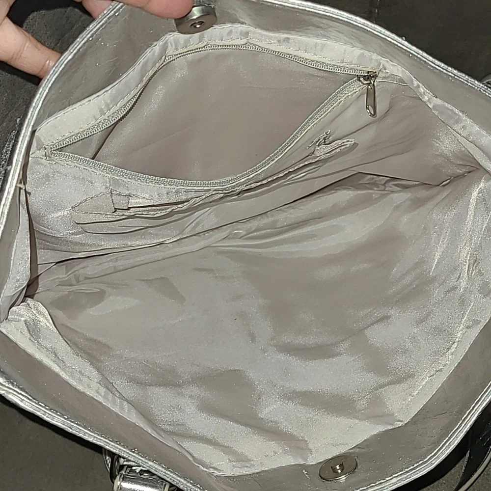 Shiny silver metallic handbag. Outside pockets snap closure‎ clean inside